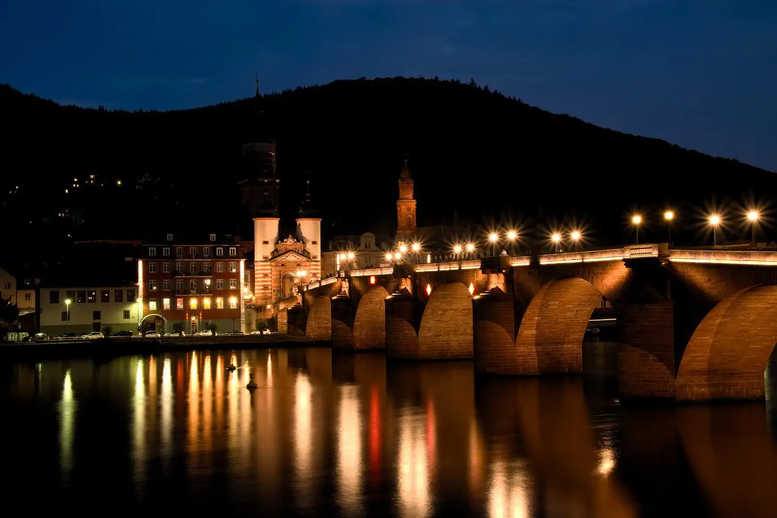 Alte Brücke und Brückentor bei Nacht mit Spiegelung im Neckar
